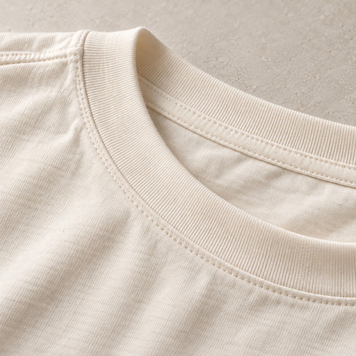 Close-up of an ecru ribbed collar and twin stitching.